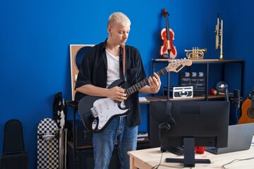 Poster - Young caucasian man musician playing electrical guitar at music studio