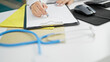 © Krakenimages.com - Young caucasian woman doctor writing on clipboard at clinic