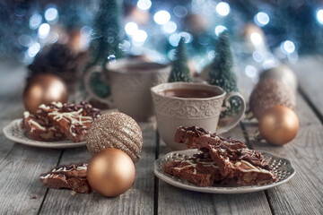 Sticker - Christmas chocolate cookies on wooden table with tea, balls and defocused lights