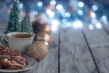 Canvas Print - Christmas chocolate cookies on wooden table with tea, balls and defocused lights. Copyspace background.