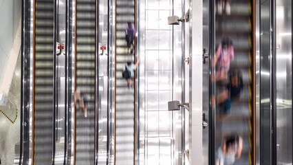 Wall Mural - Time-lapse of Asian people transport on escalator at subway underground station in Hong Kong. Public transportation, Asia city life, or commuter urban lifestyle concept. Top high angle view, tilt down