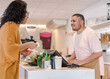 © Nexa - atendente Brasileiro recebendo o pagamento de uma cliente em uma cafeteria no Brasil