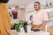 © Nexa - Brazilian man serving a customer using a computer at a coffee shop in Brazil