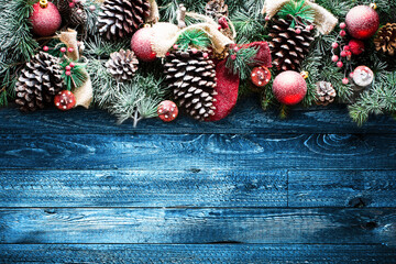 Wall Mural - Merry Christmas Frame with Snow and real wood green pine, colorful baubles, knots with berries and other seasonal stuff over an old wooden aged background