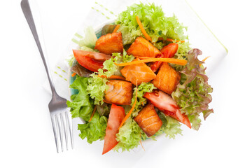 Wall Mural - Fresh vegetable salad with roasted salmon pieces. Delicious healthy salad eating.