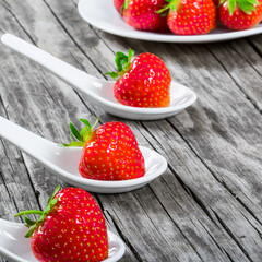 Wall Mural - strawberries on a porcelain spoons on an old rustic table