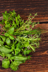 Sticker - Various aromatic culinary herbs. Fresh thyme, marjoram, basil, mint, chives and parsley herbs on plate on old brown wooden background, top view. Rustic, vintage, natural, country style images.