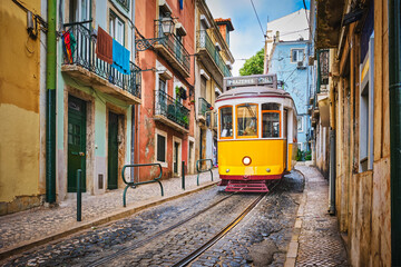 Famous vintage yellow tram 28 in the narrow streets of Alfama district in Lisbon, Portugal - symbol of Lisbon, famous popular travel destination and tourist attraction