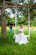 Videographer shoots a film with a bride on a rope swing