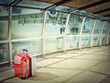 © Designpics - stack of traveling luggage in airport terminal and passenger plane flying over building in city