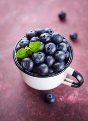 Wall Mural - Fresh blueberries in a cup. Selective focus