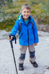 Canvas Print - Happy hiking boy with trekking sticks in the mountains. Norway