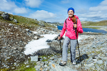 Canvas Print - Happy hiking girl with trekking sticks in the mountains. Norway