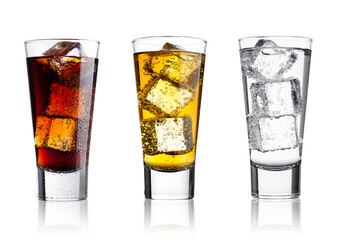 Wall Mural - Glasses of energy drink cola and  sparkling water with ice cubes and bubbles white background with reflection