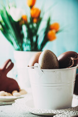 Wall Mural - Easter. Chocolate  Eggs and bunny on Easter table. Tulips in vase. Easter setting  on table