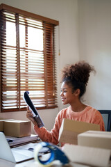 Startup young african american entrepreneur preparing cardboard box for ship to customer.