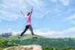 © Designpics - Young woman without backpack jumping in the mountains.