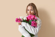 © Pixel-Shot - Young woman with beautiful peony flowers on beige background