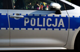 Fototapeta Miasto - Police car side door sign in Poland. Letters in Polish language, Policja means Police. Polish officers patrol vehicle.
