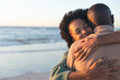 © wavebreak3 - Happy african american couple embracing and smiling on sunny beach, copy space