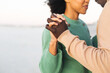 © wavebreak3 - Midsection of happy african american couple holding hands and dancing on beach