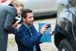 © auremar - insurance representative taking picture of car dent