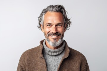 Wall Mural - Portrait of a handsome middle-aged man with gray hair in a brown sweater and gray scarf.