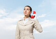 © adam121 - Young business woman holding red retro phone