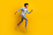© deagreez - Full size photo of nice optimistic guy wear jeans jacket pants excited running shopping on big sale isolated on yellow color background