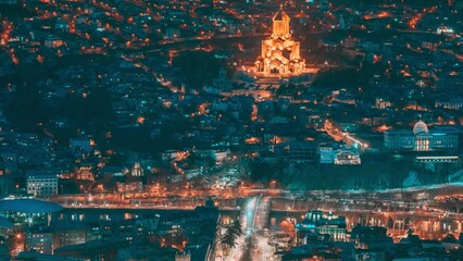 Canvas Print - Tbilisi, Georgia. Elevated top Scenic View Famous Landmark Sameba Church In Evening. Georgian Capital Skyline Cityscape Night Time lapse timelapse.