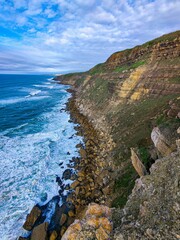 Poster - Breathtaking scenic view of the rocky coast and beach in the Atlantic ocean on a cloudy day