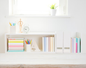 Wall Mural - wooden desk top on blurred bookshelf with school supplies background