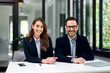 © bnenin - Portrait of a smiling business people sitting at the office table, elegantly dressed.