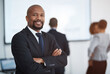© Thurstan Hinrichsen/peopleimages.com - Smile, business man and arms crossed portrait in a corporate ceo with professional management. Boss success, executive and African male manager at a office workplace with leadership and job vision