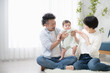© kapinon - Family in living room with cute Asian baby