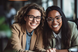Fototapeta Nowy Jork - Happy multiethnic smiling business women bonding while sitting together in office and looking at camera.
