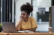 © Songsak C - A beautiful African American girl, student or businesswoman sitting at a desk and writing.