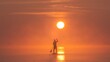 © vadimborkin - Man paddling on stand up paddle board against background of rising sun. SUP