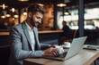 © wolfhound911 - Businessman using laptop in coffee shop. Generative AI