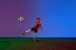 © Lustre Art Group  - Male beginner soccer player in sports uniform in action, motion with ball over dark blue background in neon. Concept of sport, health, action, ad