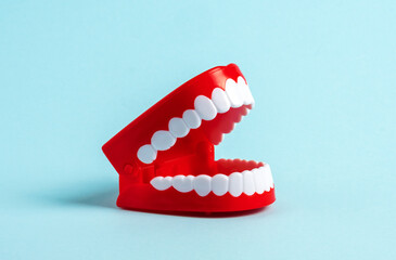 Plastic human jaw model on blue background.