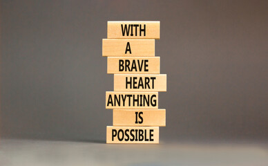 Possible symbol. Concept words With a brave heart anything is possible on wooden blocks on a beautiful grey table grey background. Business motivational brave heart possible concept. Copy space