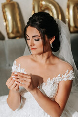 Wall Mural - portrait of a bride in a wedding dress, the girl holds her ring in her fingers