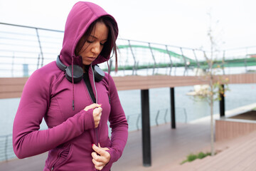 young attractive beautiful girl with headphones preparing for outdoor training