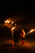 Personas en fila portando antorchas en llamas