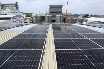 Canvas Print - Solar PV System on Factory Roof with Silo Background