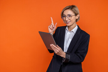 Wall Mural - Delighted woman in black official style suit raising finger having idea working online on tablet