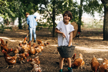 Happy boy loves feeding the chickens at the animal farm.