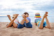 Three children lying on the sea beach in sunny day.