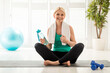 Portrait Of Smiling Senior Woman In Activewear Posing On Yoga Mat At Home